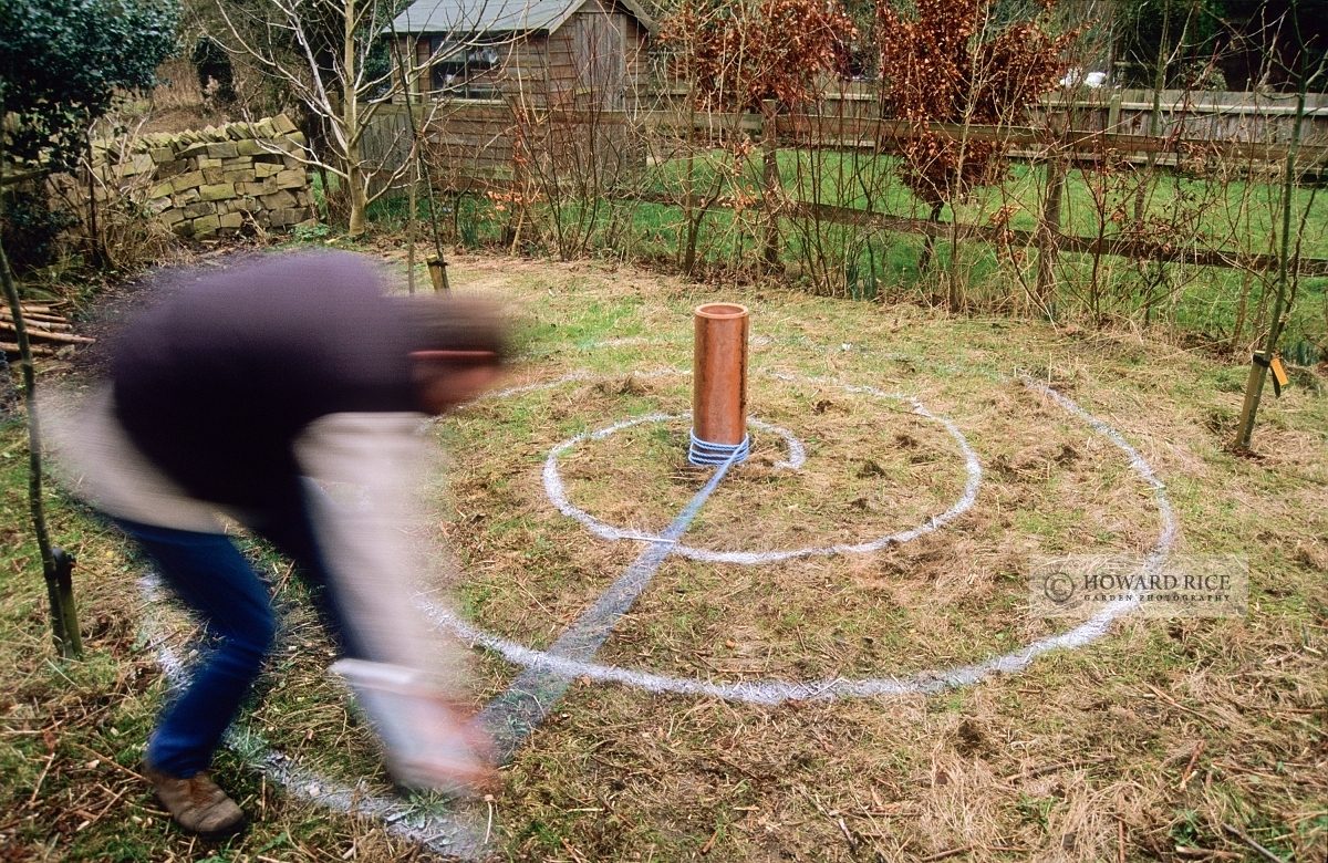 Marking spiral in rough grass ready to plant with crocus bulbs